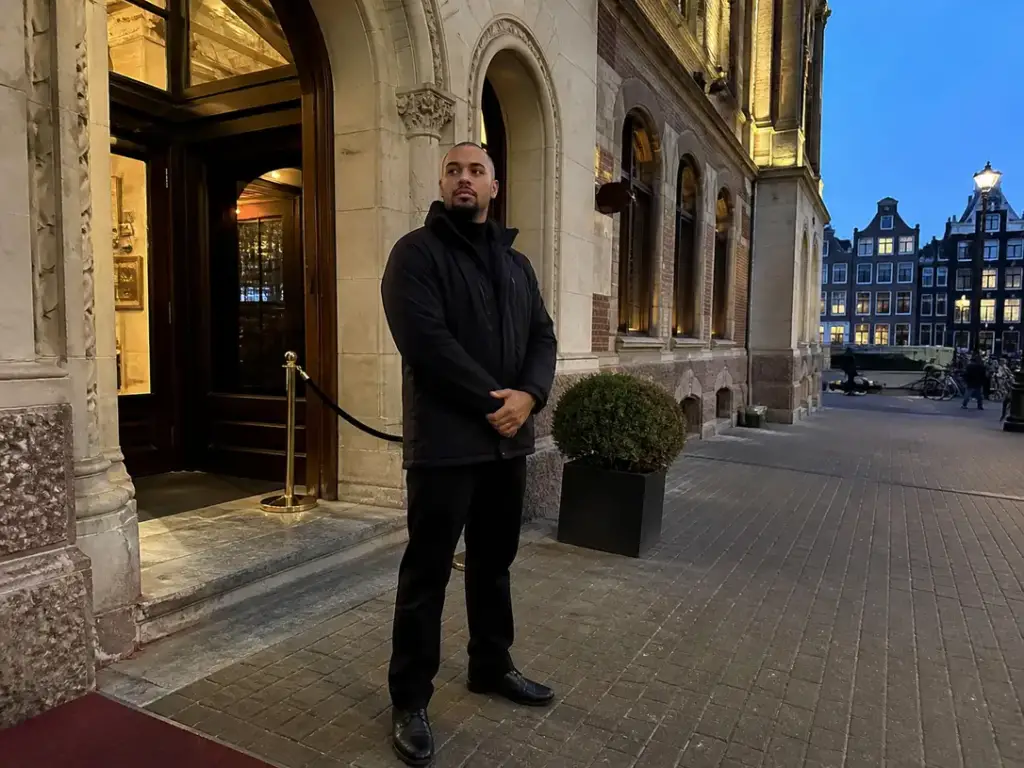 Beveiliger van Adams Security in jacket voor een gebouwsingang in Amsterdam