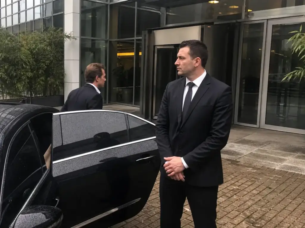 Beveiliger van Adams Security bij een auto terwijl een persoon uitstapt in Amsterdam
