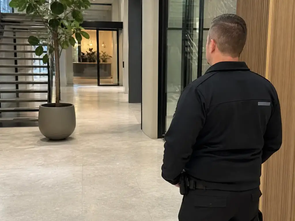 Beveiliger houdt toezicht op een trap in de hal van een gebouw