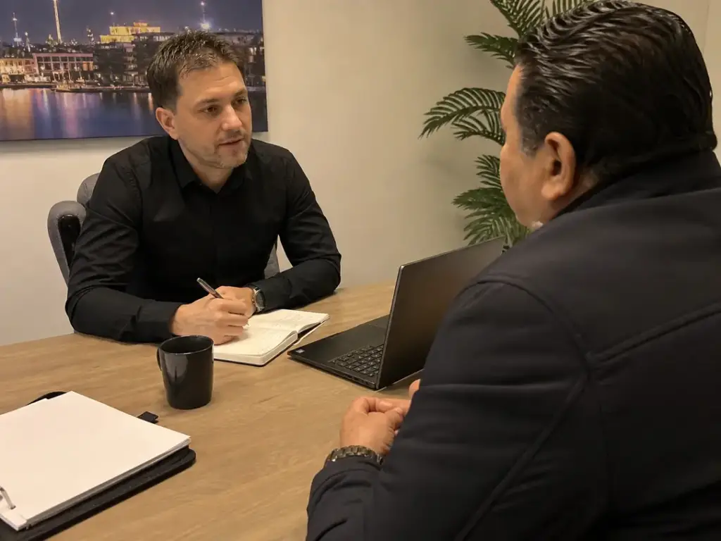 Beveiliger noteert wensen van een klant tijdens een intakegesprek voor persoonsbeveiliging