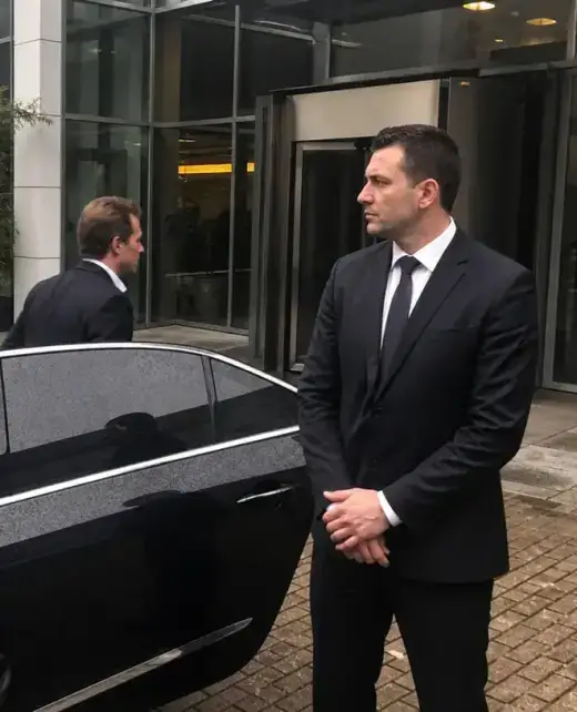 Beveiliger van Adams Security bij een auto terwijl een persoon uitstapt in Amsterdam